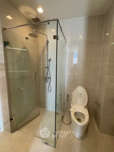 Modern bathroom with glass shower enclosure and sleek toilet design