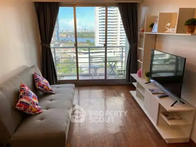 Charming living room with balcony view, modern sofa, and sleek TV setup in a high-rise apartment.