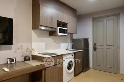 Modern compact kitchen with washing machine and microwave in stylish apartment