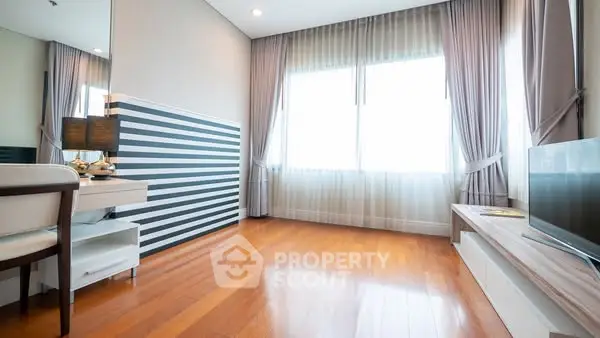 Spacious modern living room with hardwood floors and large windows