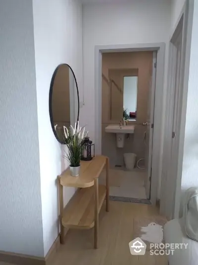 Modern hallway leading to a compact bathroom with stylish decor