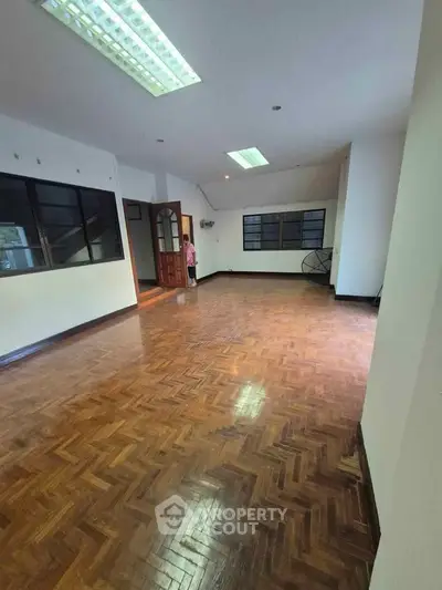 Spacious living room with wooden flooring and ample natural light
