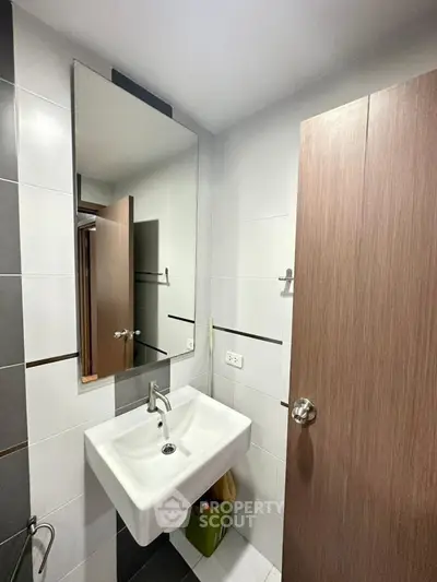 Modern bathroom with sleek sink and large mirror in a stylish apartment.