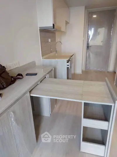 Modern compact kitchen with sleek cabinetry and integrated appliances in a stylish apartment.