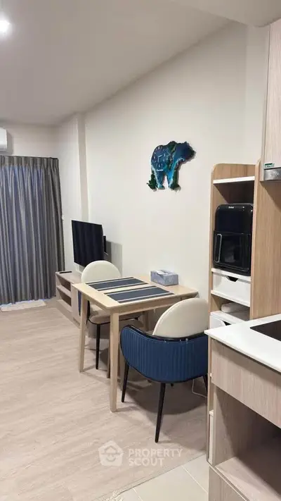 Modern living room with stylish decor and dining area, featuring a wall-mounted TV and contemporary furniture.