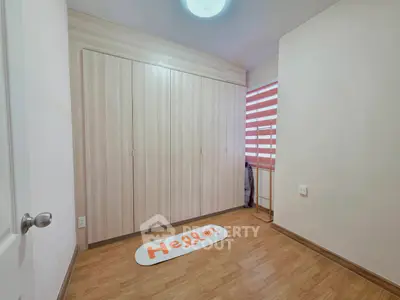 Spacious bedroom with wooden flooring and built-in wardrobe