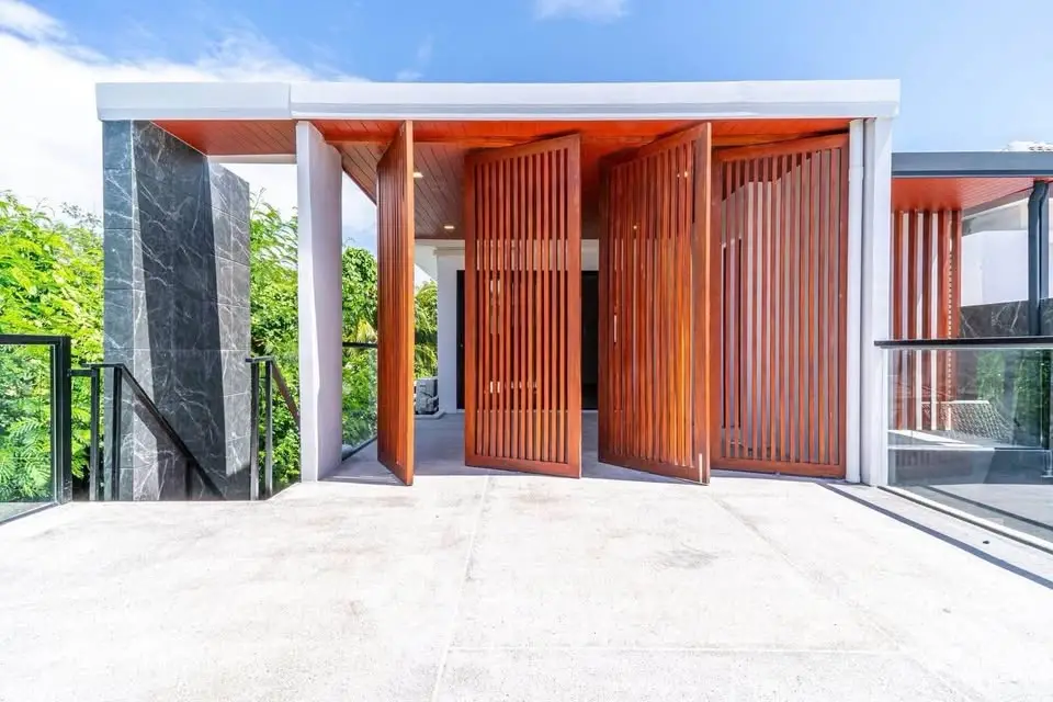 Stunning modern home entrance with sleek wooden panels and expansive outdoor space.