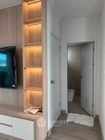 Modern living room with built-in shelving and adjacent bathroom entrance