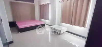 Spacious bedroom with modern design and ample natural light, featuring a comfortable bed and sleek flooring.