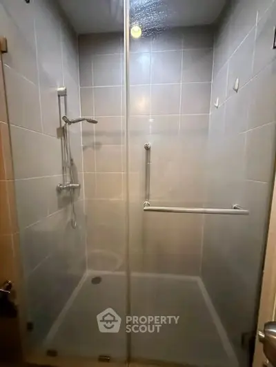 Modern shower enclosure with glass doors and sleek fixtures in a contemporary bathroom.
