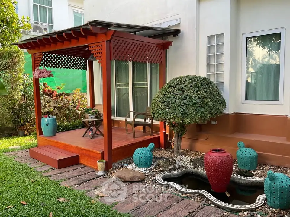 Charming garden with a wooden pergola and decorative pond, perfect for relaxation and outdoor enjoyment.