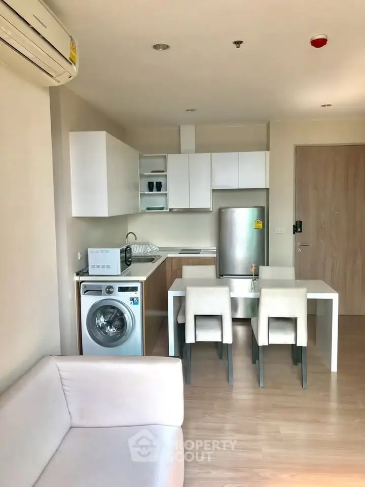 Modern kitchen with dining area and washing machine in stylish apartment