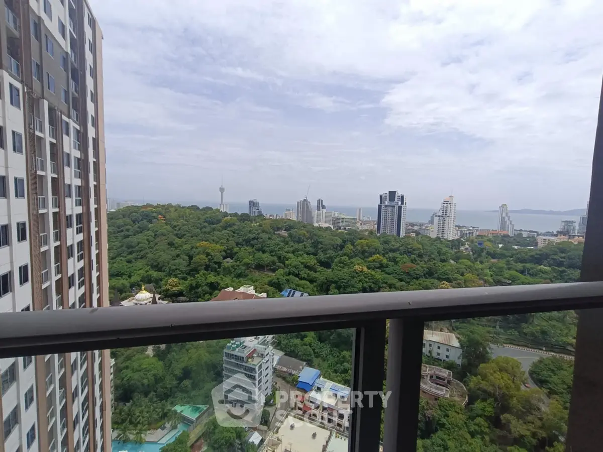 Stunning cityscape view from high-rise balcony overlooking lush greenery and skyline.