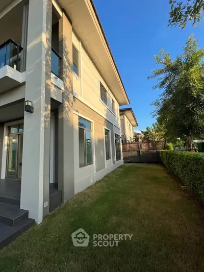 Modern two-story house with lush garden and sleek exterior design, perfect for family living.