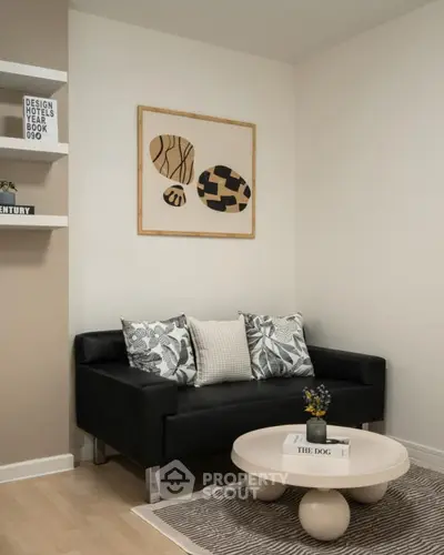 Stylish modern living room with black sofa and abstract art on wall