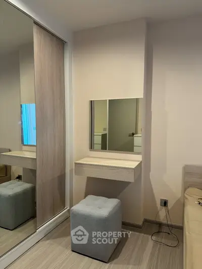 Modern bedroom with stylish vanity and mirrored closet doors