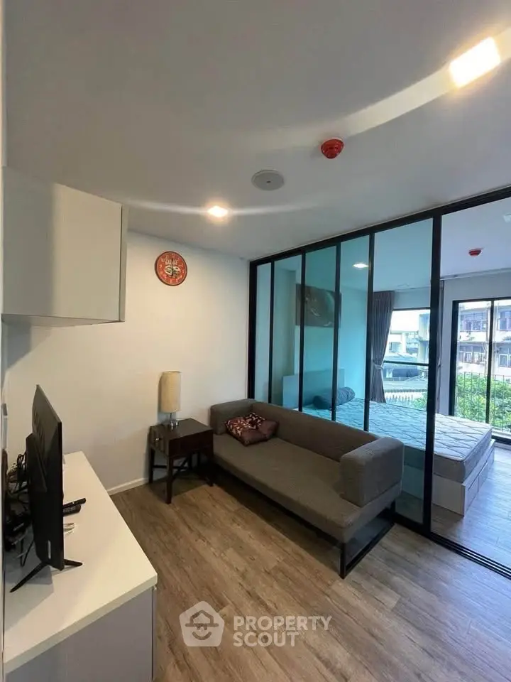 Modern living room with glass partition and cozy decor in urban apartment