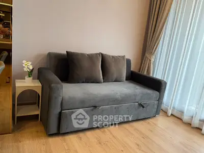 Cozy living room with plush gray sofa and elegant curtains