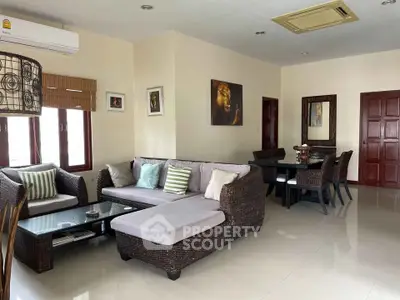 Spacious living room with modern furniture and dining area, perfect for family gatherings.