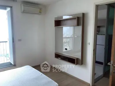 Modern bedroom with balcony access and air conditioning in a stylish apartment.