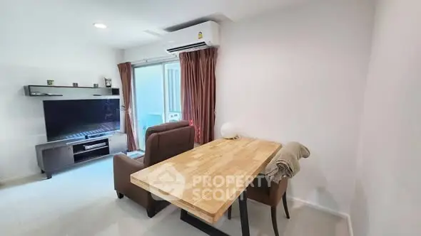 Modern living room with wooden table and TV setup, ideal for cozy gatherings.