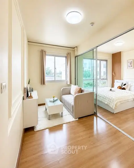 Bright and cozy living room with sliding glass doors leading to a stylish bedroom, perfect for modern living.