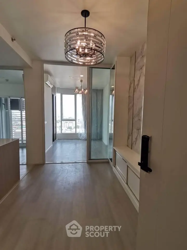 Modern apartment interior with stylish lighting and large windows offering natural light.