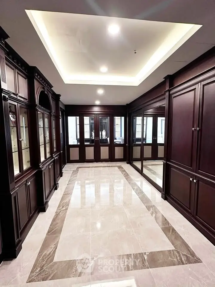 Luxurious hallway with elegant wood paneling and marble flooring in upscale building.