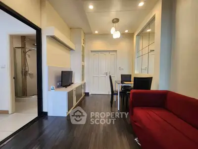 Modern living room with sleek design, red sofa, and dining area in open layout apartment.