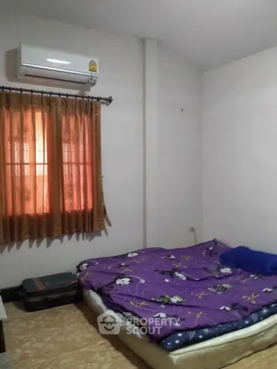 Cozy bedroom with air conditioning and natural light, perfect for relaxation.