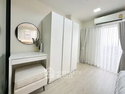 Bright and airy bedroom with modern white furniture and large window view.