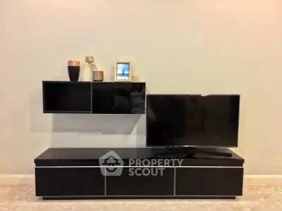 Modern living room with sleek black TV stand and wall-mounted shelves.