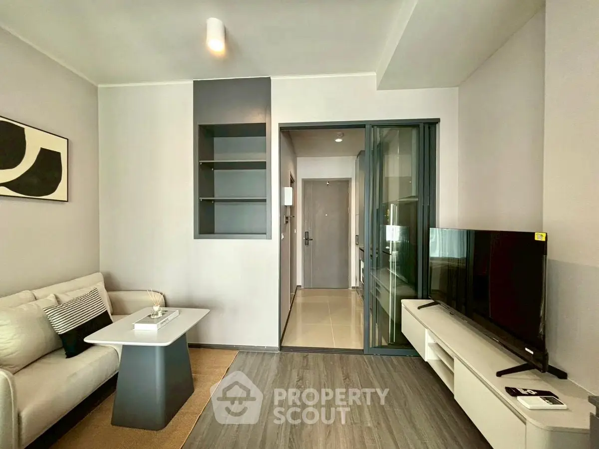 Modern living room with sleek design, featuring a cozy sofa, stylish coffee table, and a large flat-screen TV.