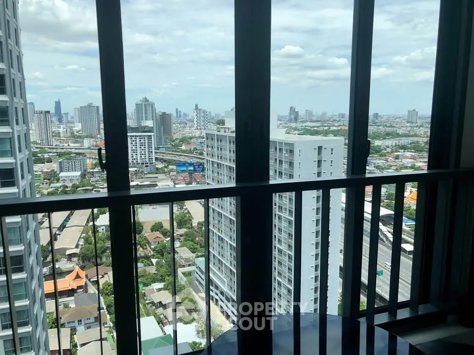 Stunning high-rise city view from a modern apartment balcony, showcasing urban skyline and vibrant cityscape.