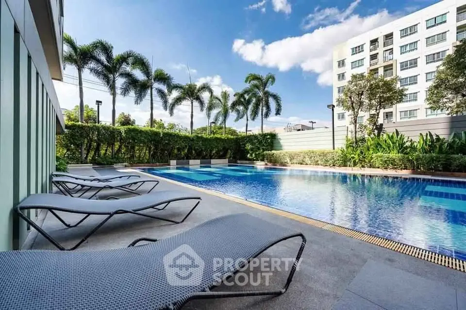 Luxurious apartment complex with a stunning outdoor pool and lush greenery.