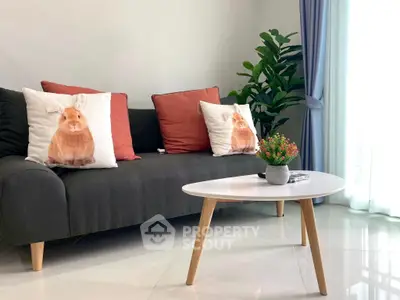 Stylish living room with modern sofa, decorative pillows, and natural light.
