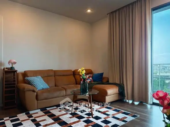 Stylish living room with leather sofa and city view balcony, perfect for modern urban living.