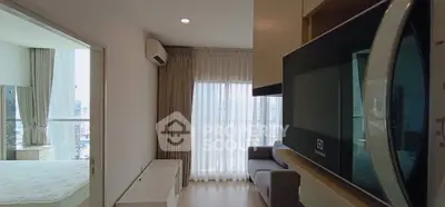 Modern apartment interior with cozy living room and bedroom, featuring large windows and natural light.