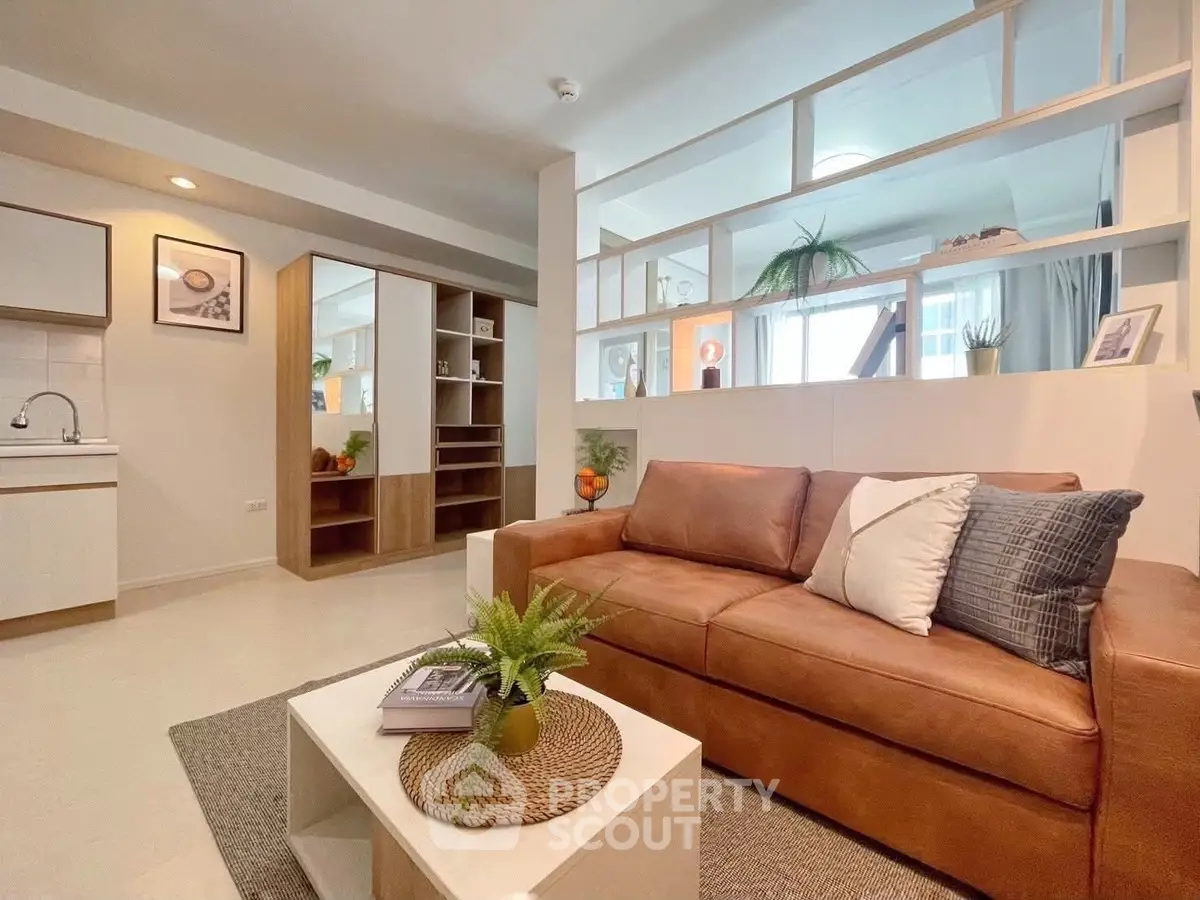 Stylish modern living room with cozy leather sofa and open kitchen layout.