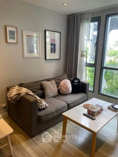 Cozy living room with modern decor and large windows for natural light.