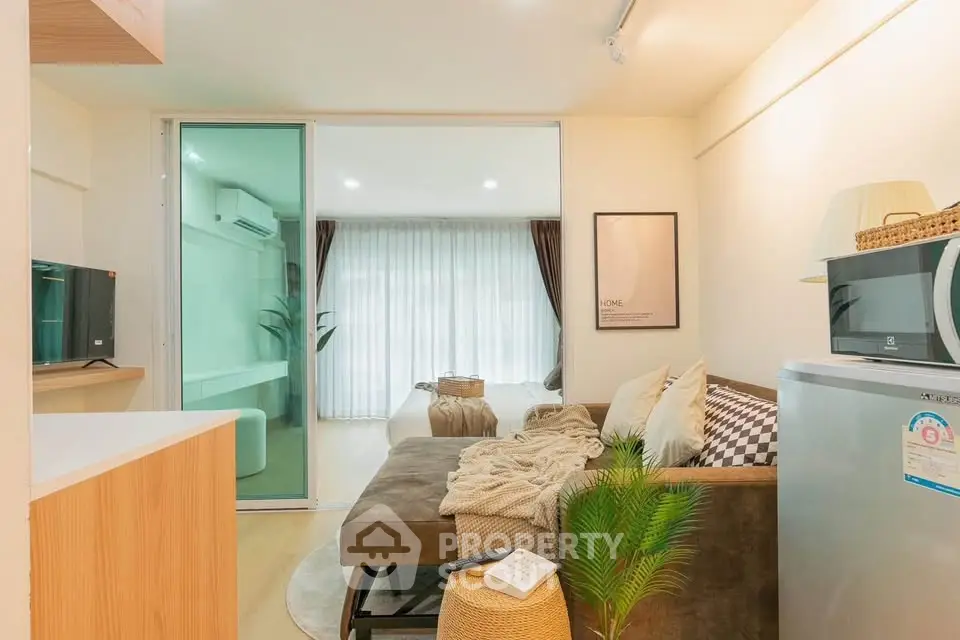 Modern living room with cozy sofa, stylish decor, and natural light from large windows.