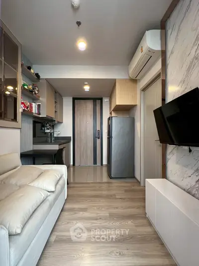 Modern living room with sleek design, open kitchen layout, and cozy ambiance.