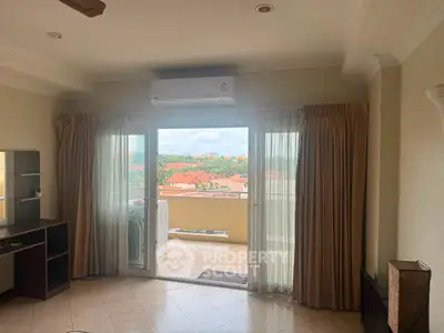 Spacious living room with balcony offering stunning views of the cityscape, perfect for relaxation and entertainment.