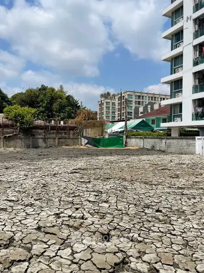 Urban construction site with cracked ground and adjacent buildings under a clear sky.