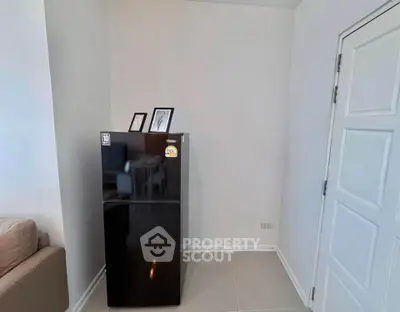 Modern apartment interior with sleek black fridge and minimalist decor