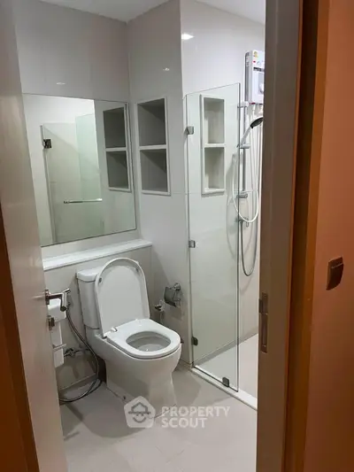 Modern bathroom with glass shower and sleek fixtures in a contemporary apartment.
