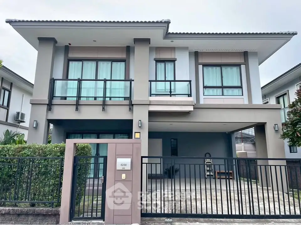 Modern two-story house with large windows and spacious driveway in a serene neighborhood.