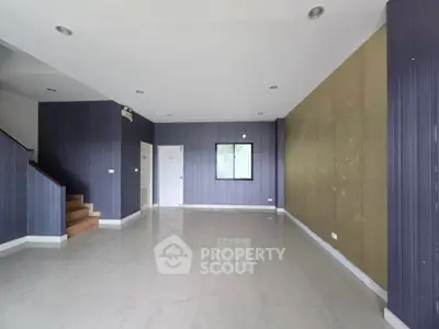 Spacious empty living room with modern design and staircase, ready for customization.
