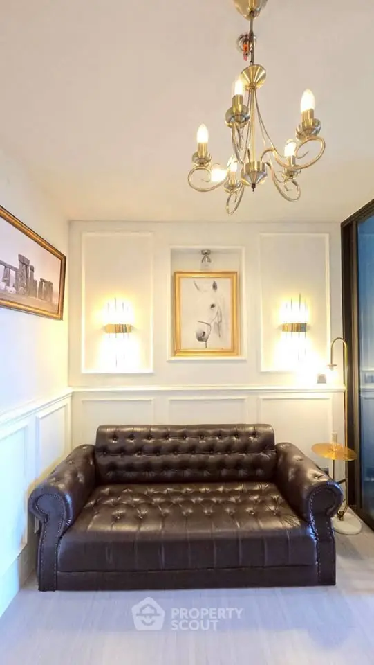 Elegant living room with leather sofa and chandelier lighting