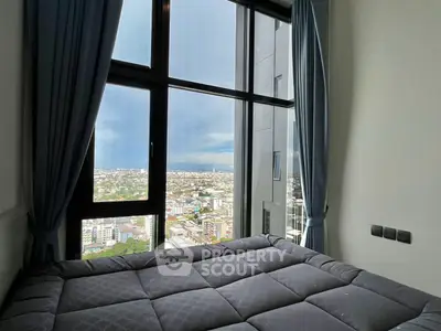 Stunning bedroom with panoramic city view through large windows, featuring elegant curtains and modern decor.